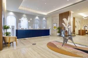 a lobby with a table and a blue wall at voco Doha West Bay Suites, an IHG Hotel in Doha