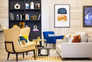 a living room with a couch and chairs at voco Doha West Bay Suites, an IHG Hotel in Doha