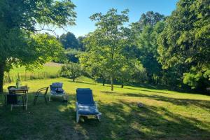 dos sillas y una mesa en un campo con árboles en Holiday Home Vito, en Stubička Slatina