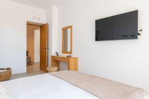 a bedroom with a bed with a flat screen tv on the wall at Villa Auretta in Pefki Rhodes