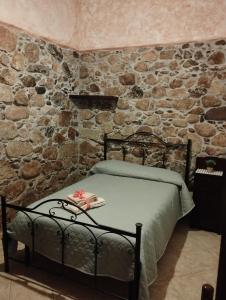 Posto letto in camera con parete in pietra. di Casa vacanza da Rosy a Gonnosfanàdiga