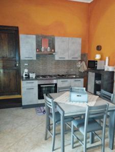 una cucina con tavolo, sedie e piano cottura di Casa vacanza da Rosy a Gonnosfanàdiga