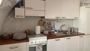 una cucina bianca con lavello e fornello di Casa DoriDa' a Lanciano
