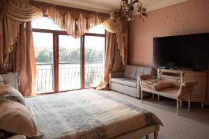 a bedroom with a large window and a television at Villa Avoti in Sigulda