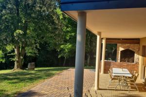 a picnic table on a brick patio with a fireplace at Holiday Home Vito in Stubička Slatina