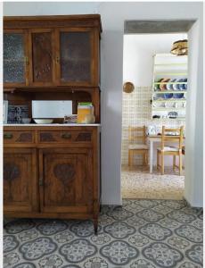 a kitchen with a wooden cabinet and a table at stone house in Kathlikaros in Mési