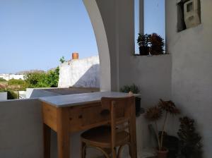 a wooden table and a chair in a room with a window at stone house in Kathlikaros in Mési