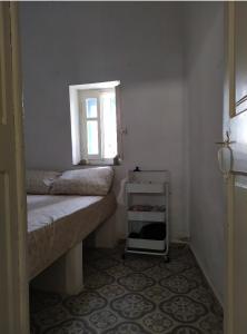 a small room with two beds and a window at stone house in Kathlikaros in Mési