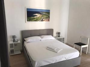 ein Schlafzimmer mit einem weißen Bett mit einem Bild an der Wand in der Unterkunft LecceMareSalento in Lecce
