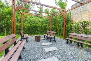 a group of benches sitting under a wooden pergola at Loft no coração da cidade de Blumenau in Blumenau