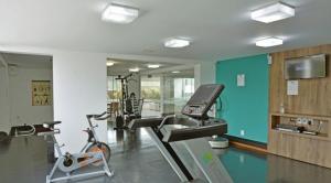 a gym with a treadmill and a bike in a room at Loft no coração da cidade de Blumenau in Blumenau