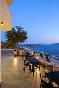 a group of tables and chairs on a patio overlooking the ocean at Sky Way SKK Luxury Apartments in Sarandë