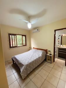 Schlafzimmer mit einem Bett und einem Deckenventilator in der Unterkunft Casa em Bombas in Bombinhas
