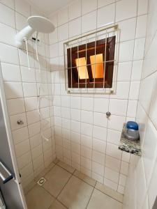 ein Bad mit einer Dusche und einem Fenster in der Unterkunft Casa em Bombas in Bombinhas
