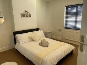 a bedroom with a large bed with white sheets at Delightful 2 bed detached home with secure parking in Huntington