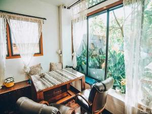 een woonkamer met een tafel en een groot raam bij Srisanor Boutique Hotel in Prachuap Khiri Khan