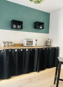 uma cozinha com um balcão e um micro-ondas em La Maison Bleue em Villefranche-Sur-Cher