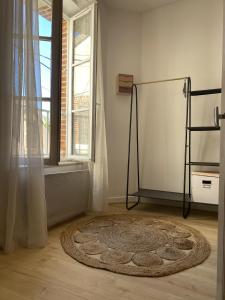 um quarto com um tapete no chão e uma janela em La Maison Bleue em Villefranche-Sur-Cher