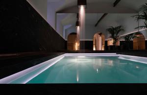 a swimming pool with blue water in a building at STRAF, Milan, a Member of Design Hotels in Milan