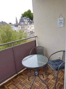 un tavolo e sedie su un balcone con vista di 4L Riverside - Naheblick im Herzen der Bad Kreuznacher Altstadt a Bad Kreuznach