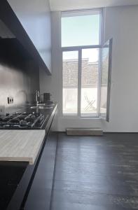 una cucina con piano cottura e una grande finestra di ANNA a Gand