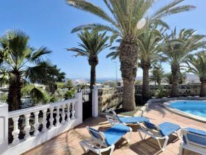 a patio with palm trees and chairs and a swimming pool at Casa Palmeral in Mácher
