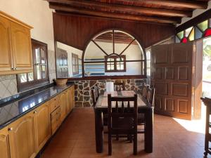 a large kitchen with a table and chairs in it at Casa Palmeral in Mácher