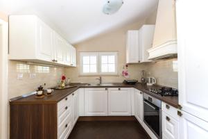 a white kitchen with white cabinets and a sink at House Glasnović in Cavtat