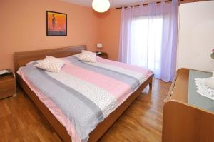 1 dormitorio con cama y ventana en Apartments by the sea Arbanija, Ciovo - 11592 en Trogir