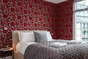 Un dormitorio con una cama con una pared roja. en Iconic Luxury Manchester Apartment, en Mánchester 19 fotos más