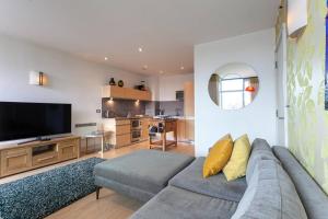 Una sala de estar con un sofá y un televisor de pantalla plana. en Iconic Luxury Manchester Apartment, en Mánchester