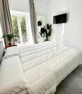 1 cama blanca en un dormitorio blanco con ventana en Apartamento Isasa, en Córdoba