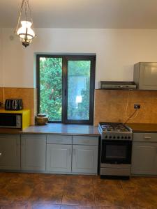 a kitchen with a stove and a window at Pensiunea Sandra in Bran
