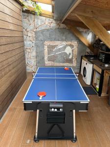 a ping pong table in a room with a kitchen at Ti case bord de mer in Saint-Benoît