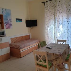 a bedroom with a bed and a table and a television at appartamento l'angolo in Capoliveri