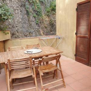 een houten tafel en stoelen op een patio bij appartamento l'angolo in Capoliveri