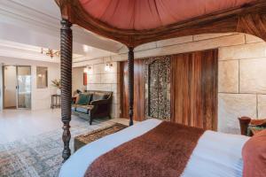 a bedroom with a canopy bed and a living room at Olinda Sandstone Apartment 2 Bedroom Spa bath in Olinda
