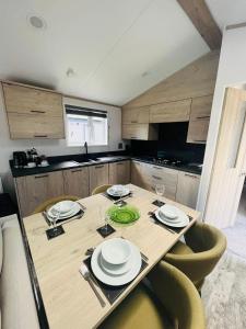 a kitchen with a wooden table with plates and glasses at Fir Tree Lodge with Hot Tub in York