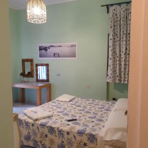een slaapkamer met een bed, een spiegel en een kroonluchter bij appartamento l'angolo in Capoliveri