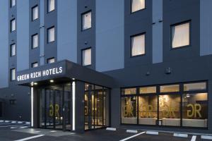 a blue building with a sign on the front of it at Green Rich Hotel Izumo (Artificial hot spring Futamata Yunohana) in Izumo