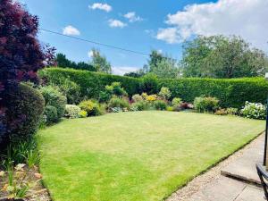 a large lawn in the middle of a garden at Cotswolds Luxury House in Central Bourton Large Sleeps 2-11. Pet Friendly. in Bourton on the Water