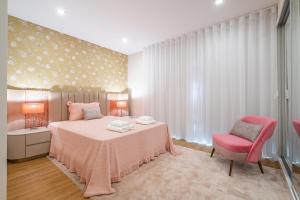 1 dormitorio con cama rosa y silla rosa en Urban Paradise by Madeira Sun Travel, en Funchal