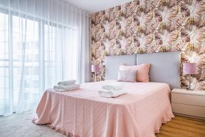 um quarto com uma cama rosa e um cobertor rosa em Urban Paradise by Madeira Sun Travel no Funchal