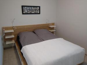 een slaapkamer met een bed met een houten hoofdeinde bij Apartment Songhill in Kuopio