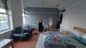 ein Schlafzimmer mit einem Bett und einem Stuhl darin in der Unterkunft London Edgware Station Apartment in London