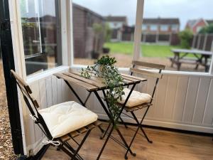 a table and chairs on a porch with a window at Delightful 2 bed detached home with secure parking in Huntington