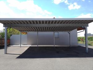 een metalen paviljoen met een dak op een parkeerplaats bij Ferienwohnung Krenn in Feldbach