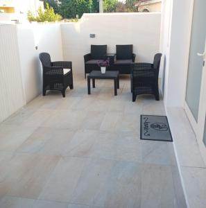 a patio with chairs and a table and a rug at Elegant basement Suite in Orosei