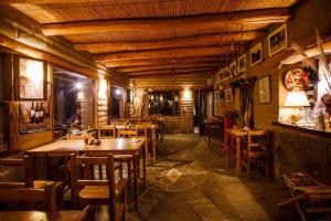 ein Restaurant mit Holztischen und -stühlen in einem Zimmer in der Unterkunft Estancia Rio de Arena 