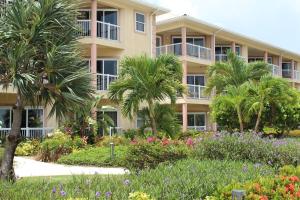 a building with palm trees and flowers in front of it at Holiday Inn Resort Grand Cayman, an IHG Hotel in George Town
